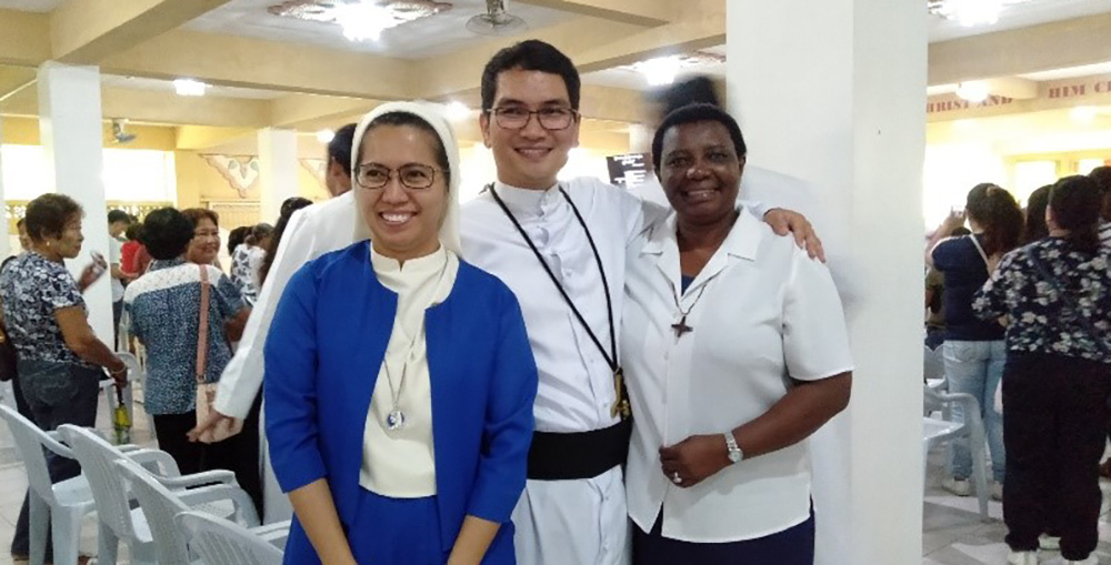 Sr. Schola Mutua (right), a Religious of Notre Dame of the Missions, with an Oblate of Notre Dame sister and a priest of Oblate of Mary Immaculate, during the first profession of some Oblate of Mary Immaculate brothers