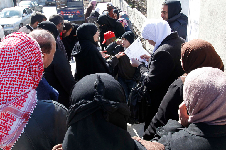 Syrian refugees living in Jordan wait to receive humanitarian supplies in Amman Feb. 5. (CNS/Reuters/Muhammad Hamed)