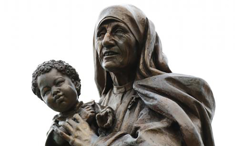 A statue of Blessed Teresa of Kolkata holding a child is seen in a prayer garden at Cure of Ars Church in Merrick, N.Y. (CNS/Gregory A. Shemitz)