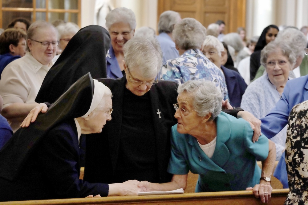 Sr. Ann Francis Hinkel exchanges the sign of peace with Sr. Nena DeMatteo as Sr. Regina Marie Grehan embraces them during an Oct. 30 Mass at the Cathedral of the Incarnation in Nashville marking the 150th anniversary of service by the Sisters of Mercy in Tennessee. (CNS/Rick Musacchio, Tennessee Register)