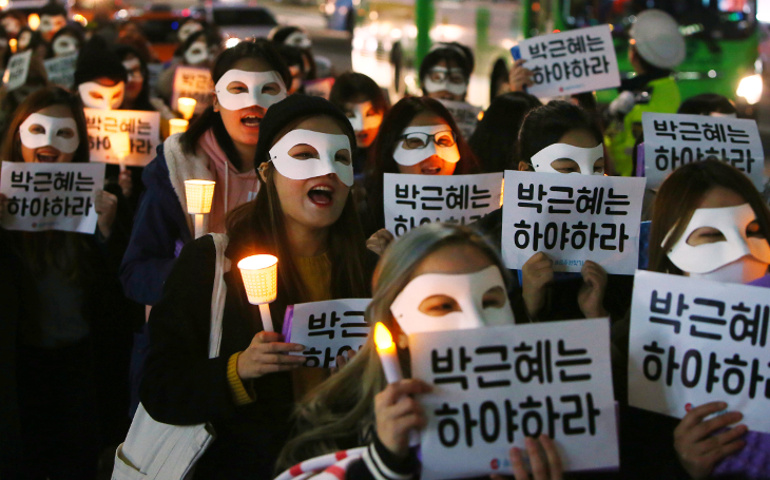 South Korean university students carry candles and placards that read "Park Geun-Hye Step Down" Nov. 15 in Seoul. (CNS/EPA/Yang Ji-Woong)