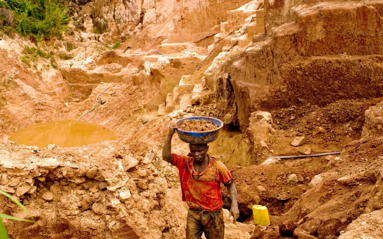 A Congolese mine worker carries gold rich earth out of a pit for water processing in 2009 in Chudja. Church leaders say telling companies they no longer have to disclose whether their firms use "conflict minerals" would be a bad move. (CNS photo/Marc Hofer, EPA)