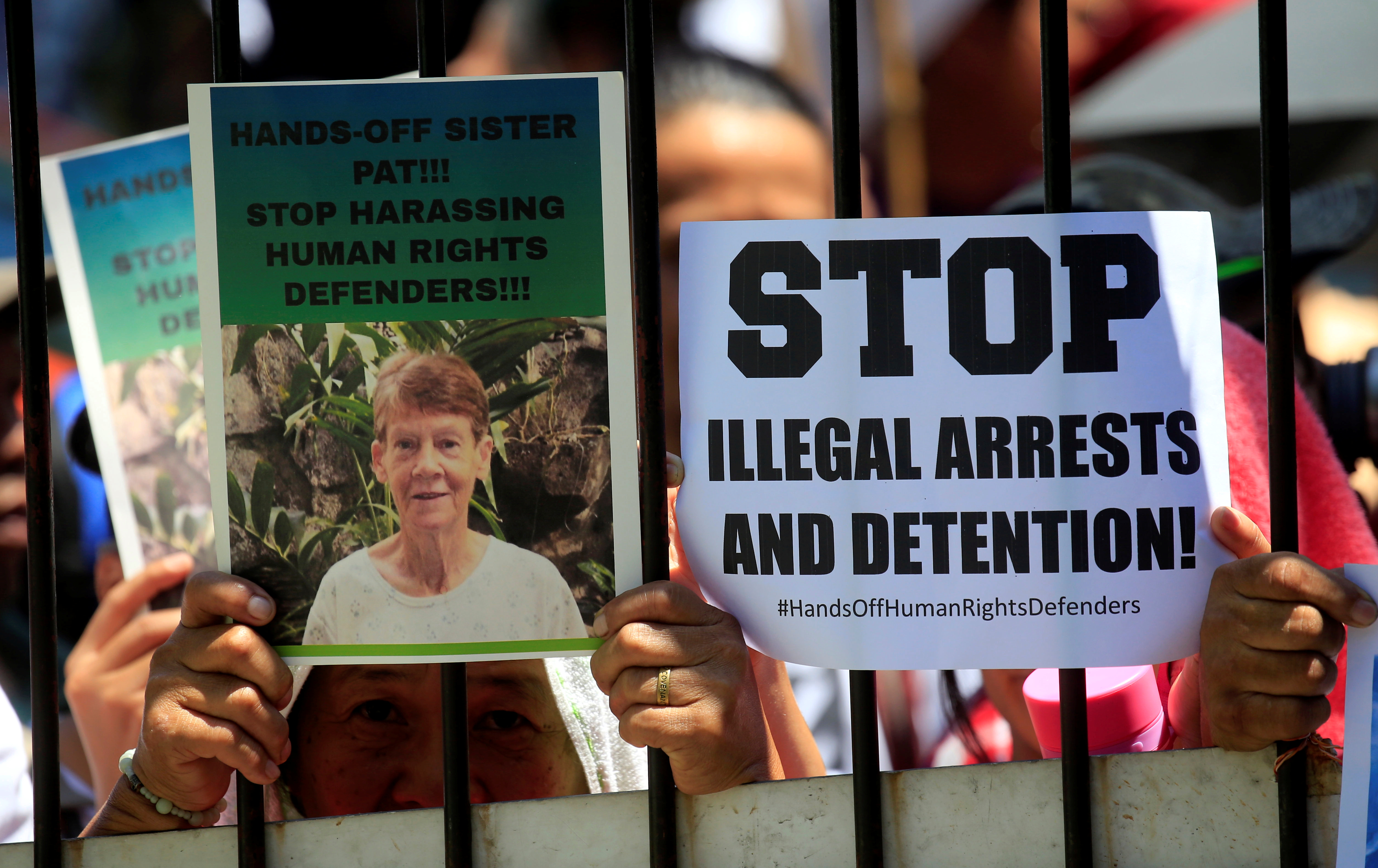 Supporters of Sister Patricia Fox, superior of the Sisters of Our Lady of Sion in the Philippines, hold placards while waiting for her April 17 release from the Bureau of Immigration headquarters in Manila. Philippine authorities arrested the 71-year-old Australian nun for allegedly engaging in illegal political activities. (CNS/Romeo Ranoco, Reuters)