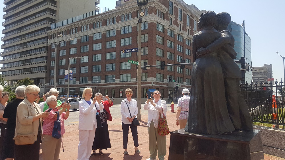 Sisters from the Leadership Conference of Women Religious take photos of the statue of Dred and Harriet Scott outside the Old Courthouse in downtown St. Louis on Aug. 10. (GSR photo / Gail DeGeorge)