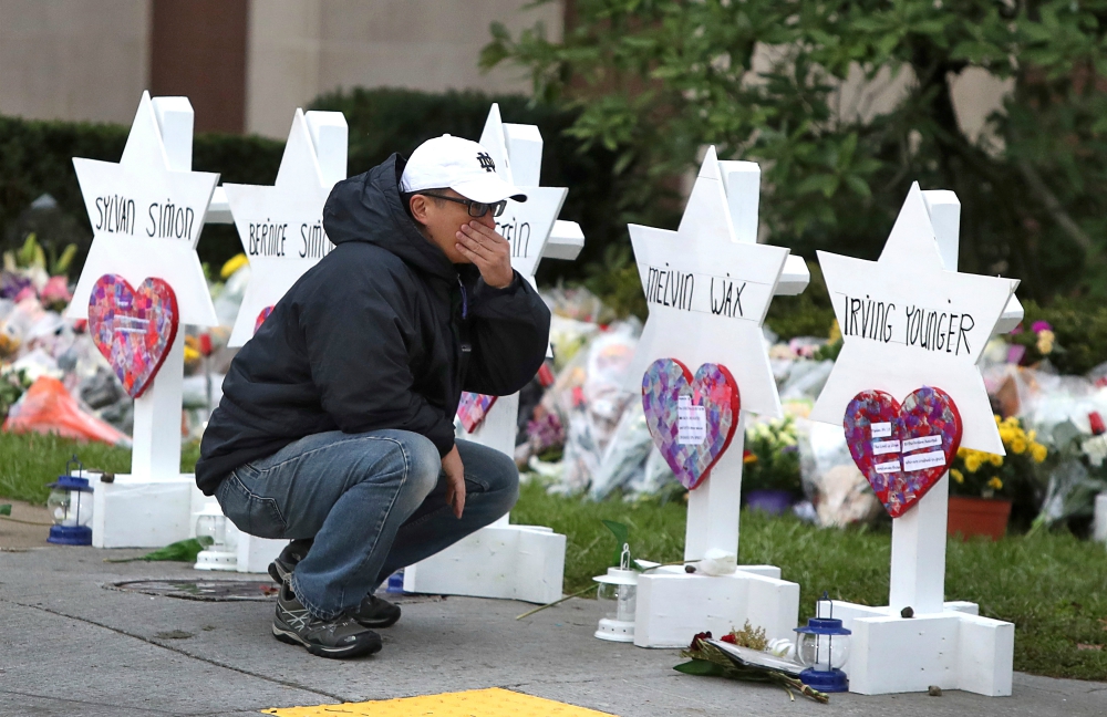 A young man reacts Oct. 29 at a makeshift memorial outside the Tree of Life synagogue in Pittsburgh. (CNS / Reuters / Cathal McNaughton)
