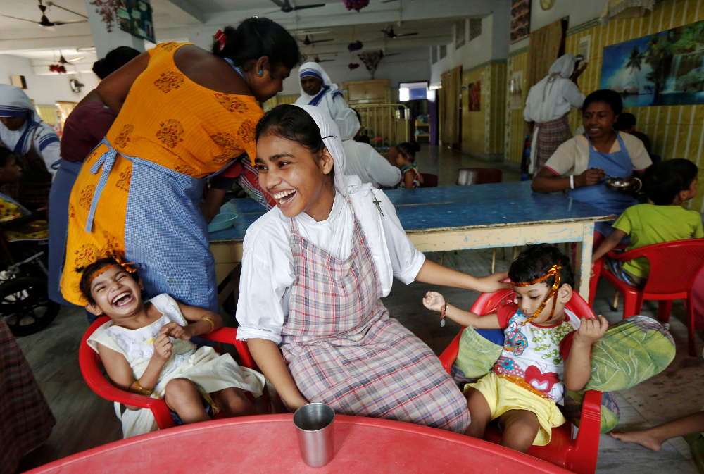 A member of the Missionaries of Charity laughs as she interacts with children in 2016 at Nirmala Shishu Bhavan, a children's orphanage founded by St. Teresa of Kolkata in India. (CNS/Rupak De Chowdhuri, Reuters)