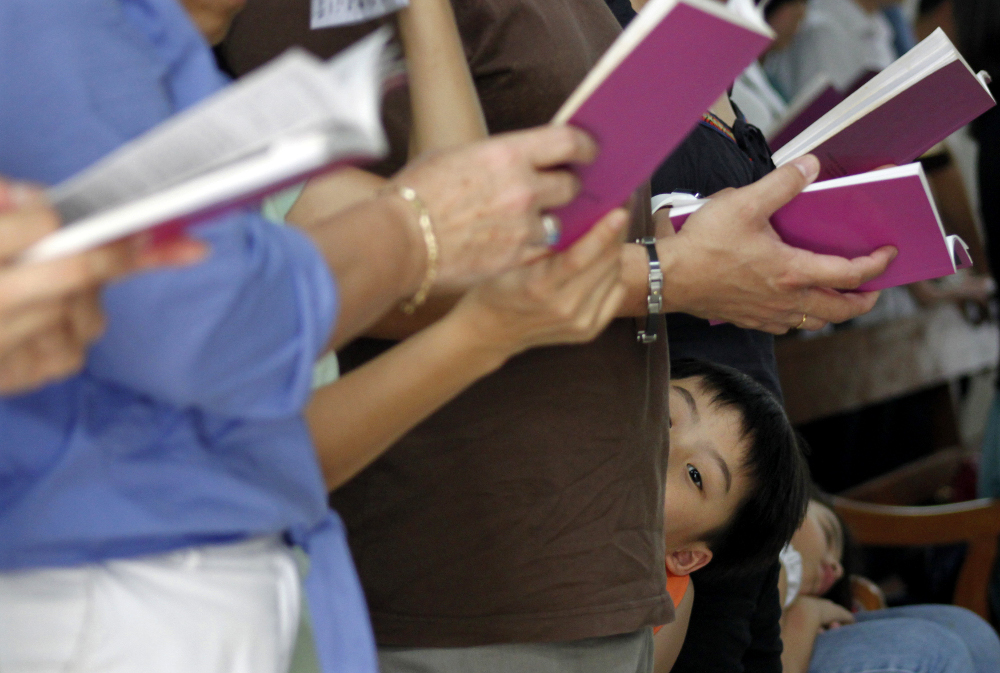 A boy attends Mass with his family at the Church of Sts. Peter and Paul in Singapore April 2, 2010. (CNS/May Naji, Reuters)