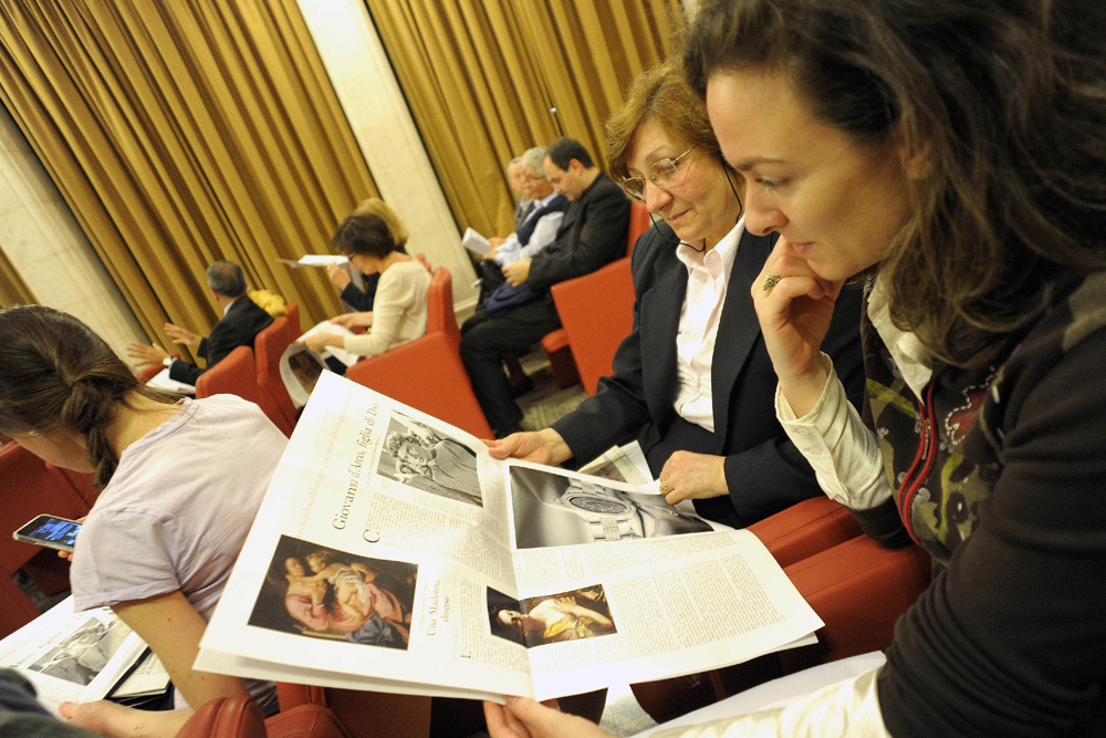 Women look at "Women Church World," a monthly women's magazine insert in the Vatican's L'Osservatore Romano newspaper, in this file photo. (CNS/L'Osservatore Romano via Reuters)