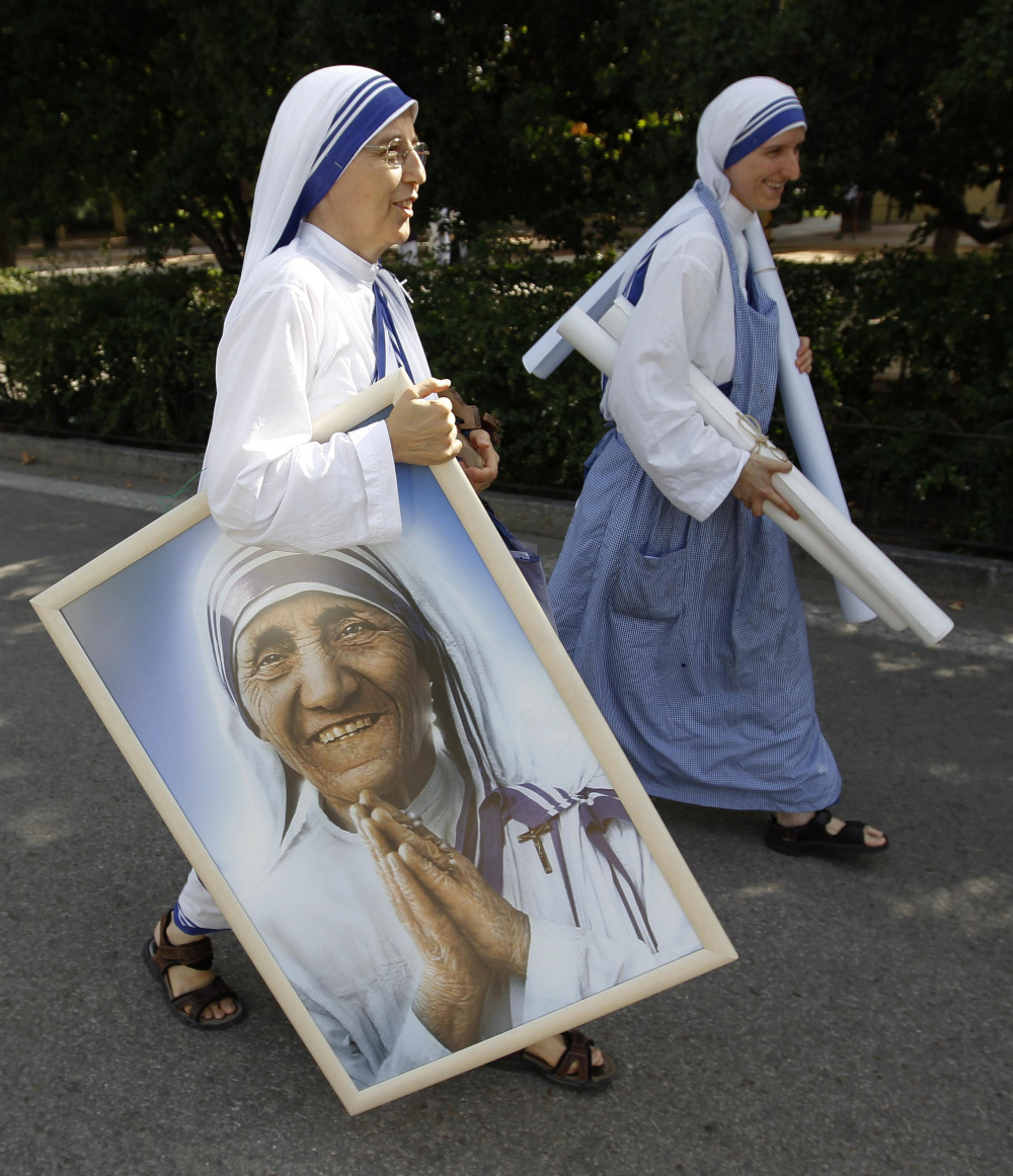 In this 2011 file photo, a member of the Missionaries of Charity carries a portrait of St. Teresa of Kolkata in Madrid's Buen Retiro park. (CNS/Reuters/Andrea Comas)