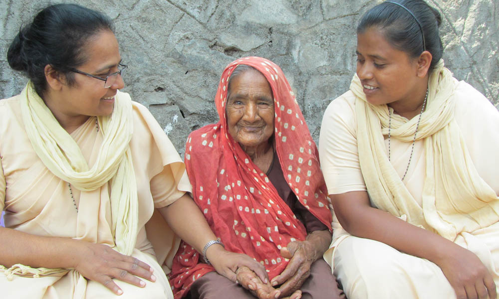 Sr. Grace Kollencherry and Sr. Nirmala Bahara with an elderly woman in a slum of Rajkot town, in the western Indian state of Gujarat (Saji Thomas)