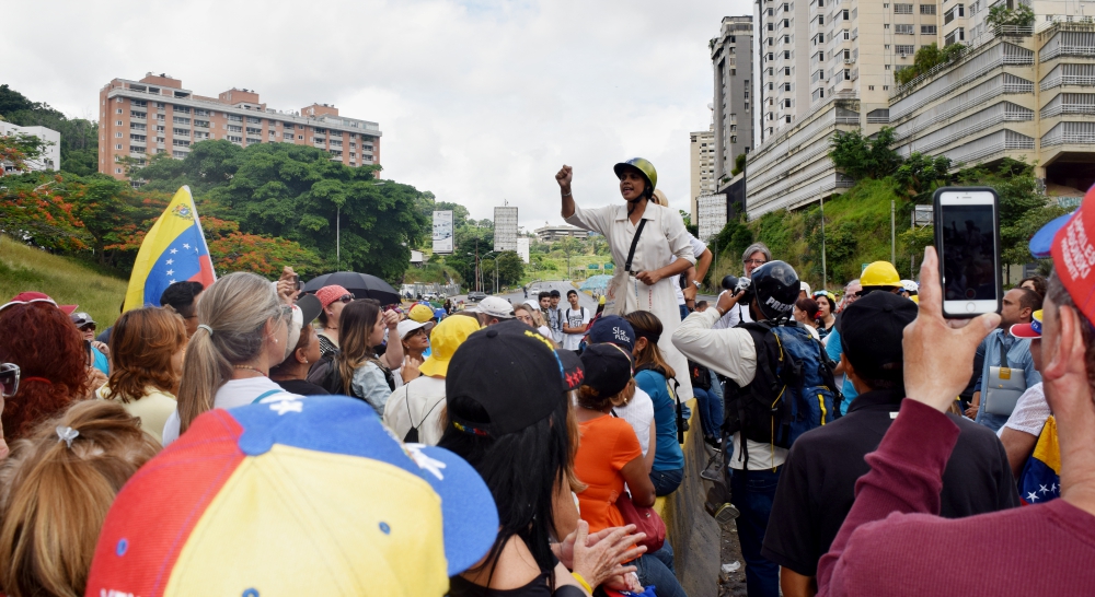 Dominican Sr. Zulay Luján leads protesters in a prayer as an anti-government sit-in protest begins June 14 on a highway in Caracas, Venezuela. (Cody Weddle)