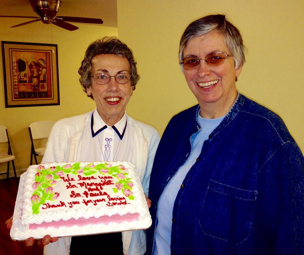Charity Sr. Paula Merrill, right, and School Sister of St. Francis Margaret Held celebrate the anniversary of their vows at St. Thomas the Apostle Catholic Church in Lexington, Mississippi. The cake reads: "We Love You Sister Margaret and Sister Paula. Thank you for your loving service." (Courtesy of the Sisters of Charity of Nazareth)