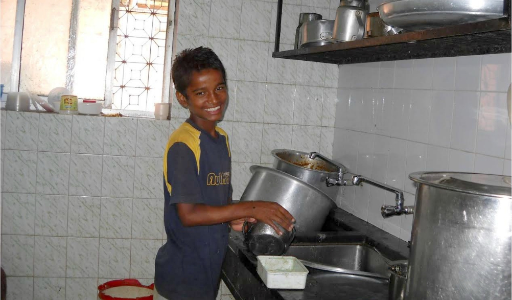 A boy washes dishes in a Snehasadan house outside Mumbai, India. (Provided photo)
