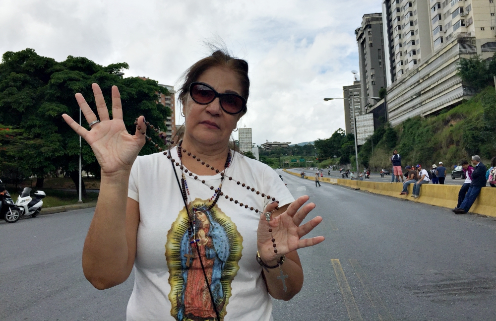 María José Feguera shows her rosary at an anti-government protest June 14 where she was praying for peace. (Cody Weddle)