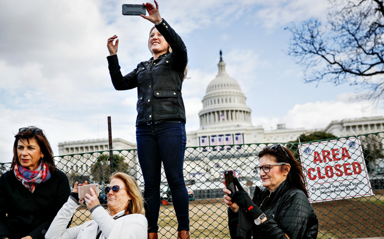 Micaela Johnson, of Leawood, Kan., in town to take part in Saturday's Women's March on Washington, takes a selfie with the Capitol Building in the background Jan. 18. (AP/John Minchillo)