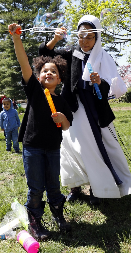 A child and Sister Antoniana Maria, a member of the Sisters of Life, play with bubbles during the annual Mother's Day celebration May 8 at the religious community's retreat house in Stamford, Conn. Founded 25 years ago, the Sisters of Life provide outreach to pregnant women in crisis and offer continuing support to them following the birth of their children. More than 70 women and 200 children ministered to by the nuns attended this year's celebration. (CNS photo / Gregory A. Shemitz)