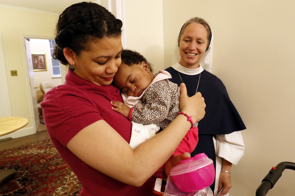 Claudia Gutierrez holds her six-month-old daughter Esther as Sister Mary Elizabeth, vicar general of the Sisters of Life, looks on May 4 at the religious community's Holy Respite residence in the Hell's Kitchen neighborhood of New York City. Holy Respite serves as a home and support center for pregnant women in crisis and new mothers. (CNS photo / Gregory A. Shemitz)