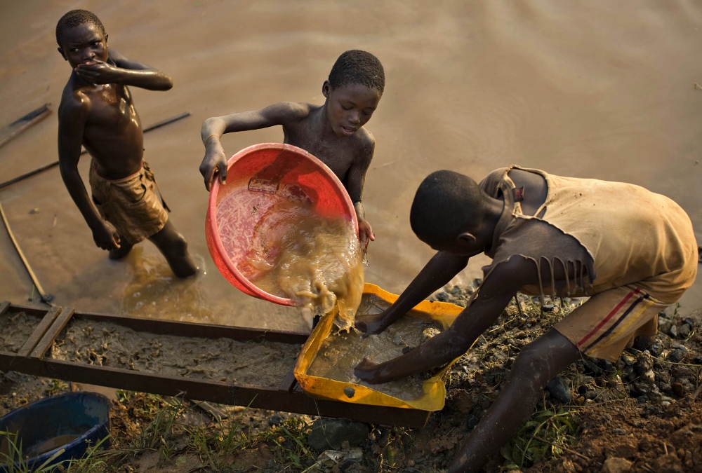 Boys pan for gold on a riverside at Iga Barriere in the resource-rich Ituri region of northeastern Democratic Republic of Congo, about 900 miles away from Kolwezi, in February 2009. (CNS photo / Finbarr O'Reilly, Reuters)