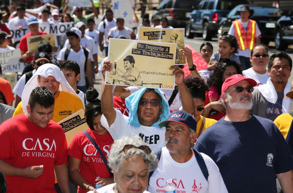 A man displays a sign during an immigration march and rally near the U.S. Immigration and Customs Enforcement headquarters in Washington Aug. 28. Taking photographs of the Artesia facility where families are being detained is prohibited by U.S. officials. (CNS photo/Bob Roller)