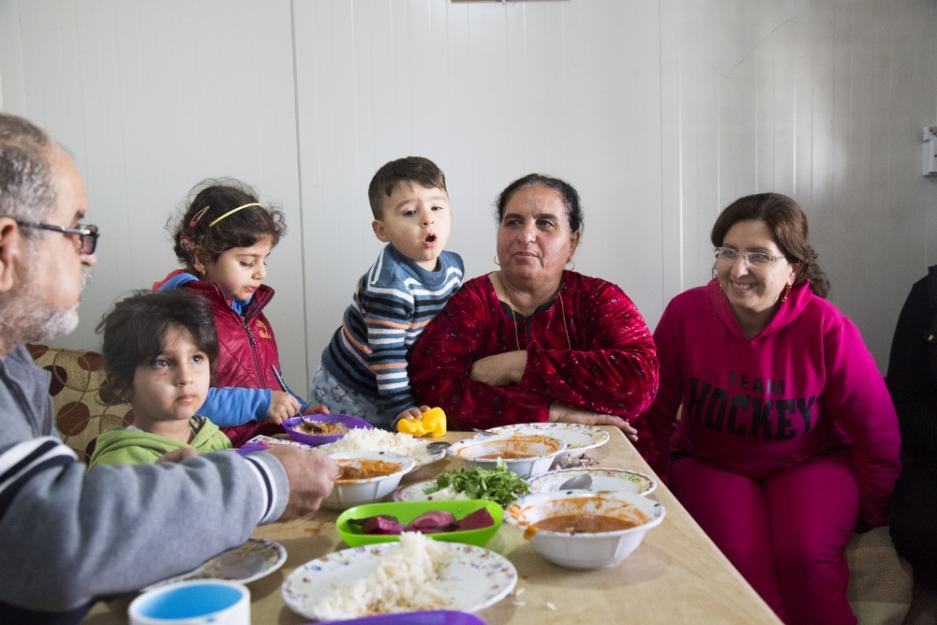 Habiba Daud, second from right, and her family have lunch Dec. 2015 in their trailer at Ashti 2, a camp for internally displaced people in Irbil. The family is from a northern Iraq town overun by the Islamic State group in August 2014. (CNS/Oscar Durand)