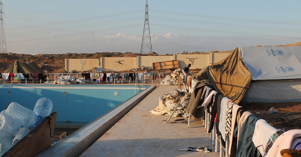 Blankets line a fence where where Iraqi Christians are sheltered by Dominican Sisters of St. Catherine of Siena outside a youth sport center in Ainkawa, Iraq. An early wintery deluge drove out families, adding to the woes for those who recently ran for their lives from the brutal Islamic State militant takeover of Iraq's historic Christian heartland. (CNS photo/Dale Gavlak)