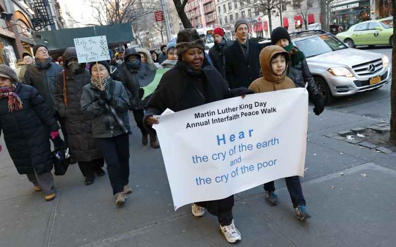 Anastasie Vital and Ian Chen-Adamczyk carry the lead banner during the annual Martin Luther King Jr. Day Interfaith Peace Walk Jan. 18 in the Upper West Side neighborhood of New York City. (CNS photo/Gregory A. Shemitz)