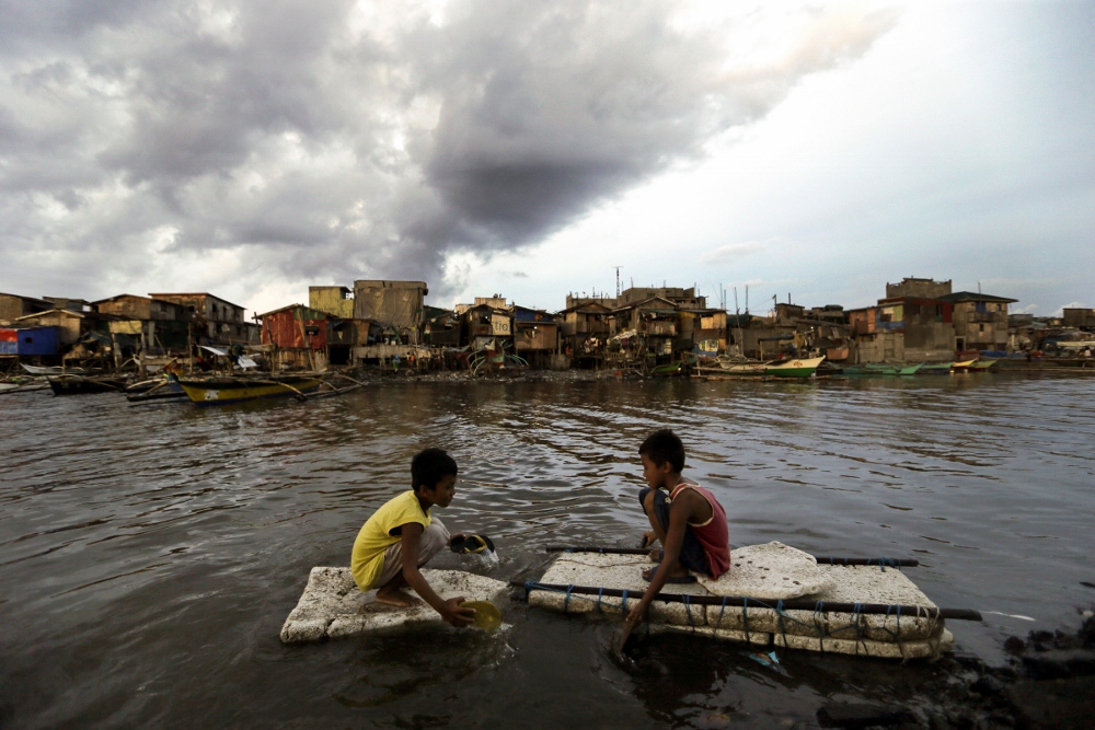 Children paddle in water in Navotas City, Philippines, May 10. (CNS photo / Ritchie B. Tongo, EPA)