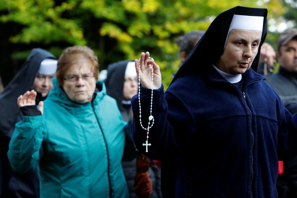 Nuns and others pray as they walk through the forest during an Oct. 7, 2017, mass rosary prayer on the Polish-Czech border near Szklarska Poreba, Poland. (CNS/Reuters/David W Cerny)