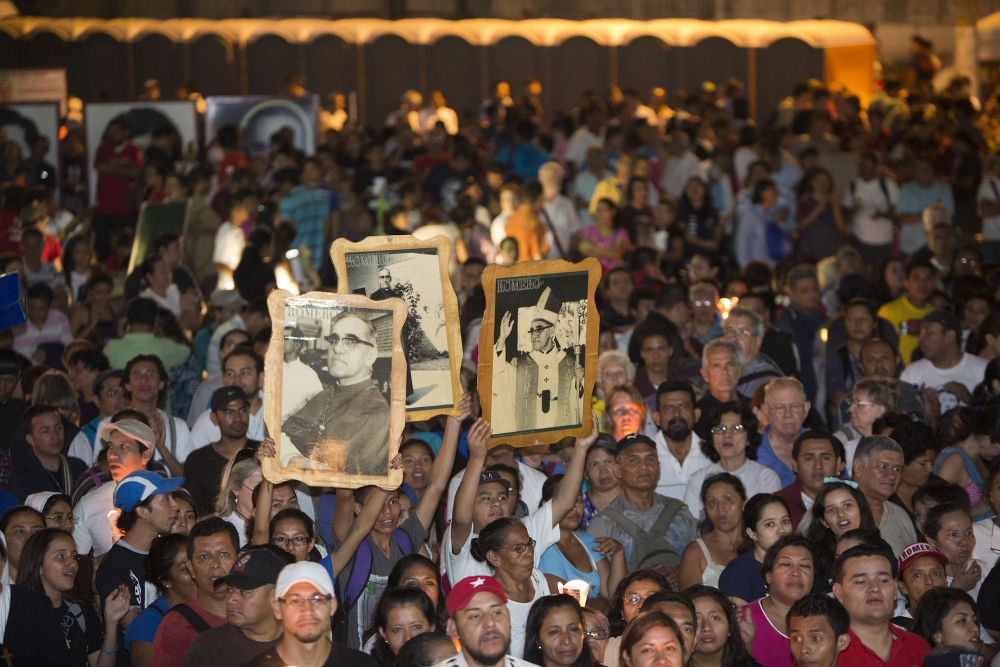 People hold up images of Archbishop Oscar Romero during an outdoor Mass March 21, 2014, in San Salvador to mark the 35th anniversary of his death. The archbishop was fatally shot as he celebrated Mass March 24, 1980. (CNS photo / Octavio Duran)