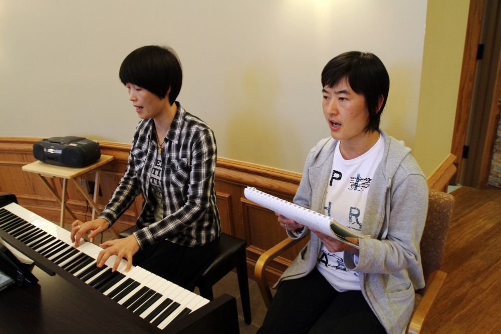 Chinese Srs. Jean Qi Zhi Zhen, left, a member of the Sisters of St. Theresa of the Child Jesus, and Paulina Feng Shuang, a member of the Fushun Sisters of the Sacred Heart of Jesus, lead the music during Mass at the Cenacle Retreat Center in Ronkonkom a, N.Y., Aug. 20. (CNS photo/Gregory A. Shemitz)