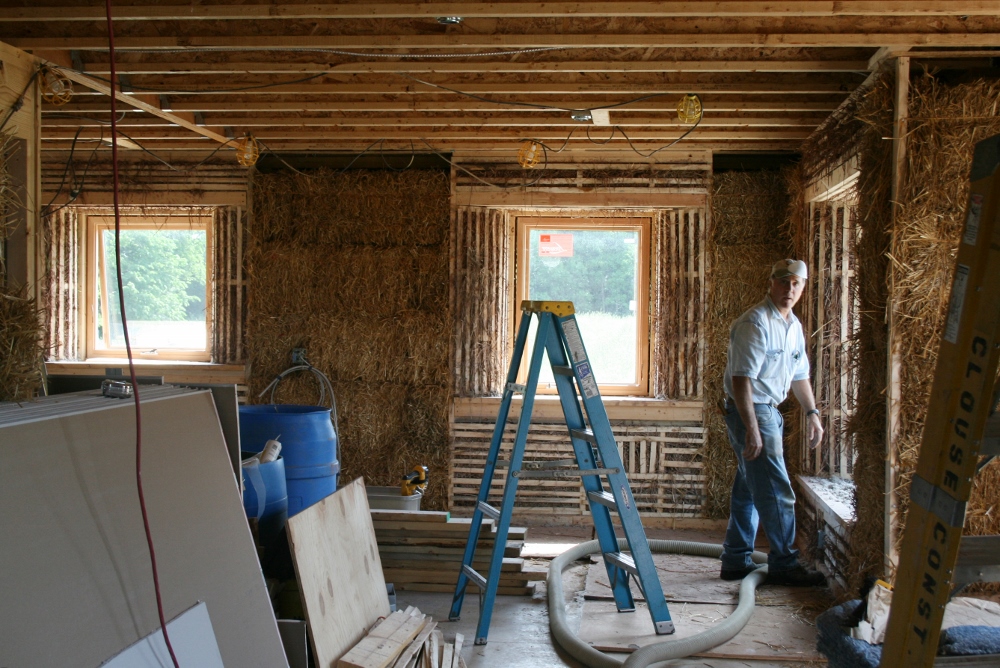 A worker puts straw bales inside the walls of a house using alternative construction materials on the grounds of the Sisters of St. Francis of Tiffin, Ohio. (CNS photo/courtesy Sisters of St. Francis of Tiffin)
