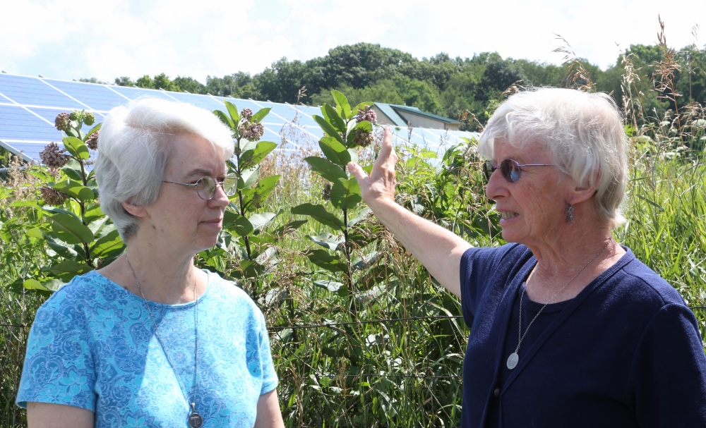 St. Francis Sr. Jacqueline Doepker and St. Francis Sr. Jane Frances Omler talk in front of solar panels near the energy-efficient straw-bale house they helped build. (CNS photo/Chaz Muth)
