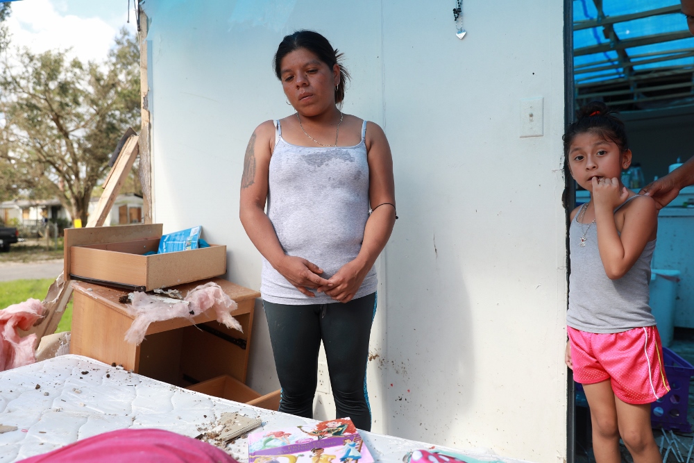 Sandra Guzman and her daughter, Maria Valentine Romero, Sept. 12 in their mobile home, which now has a tarp instead of a roof after the passing of Hurricane Irma in Immokalee, Florida. (CNS / Reuters / Stephen Yang)