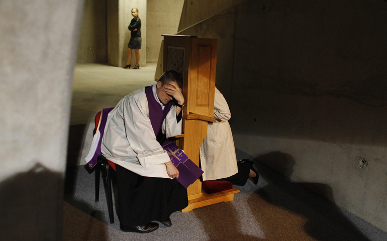 A priest listens to a confession during Mass in 2012 at the Temple of Divine Providence in Warsaw, Poland. (CNS/Reuters/Kacper Pempel)