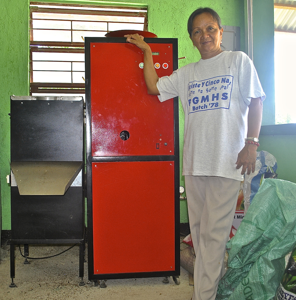Vicky De Guzman, treasurer of Casile-Guinting Upland Marketing Cooperative showed visitors how to operate the coffee roaster invented for Philippines farmers by Fair Trade Practitioner Basil Reyes, President of Bote Central. (N.J. Viehland)