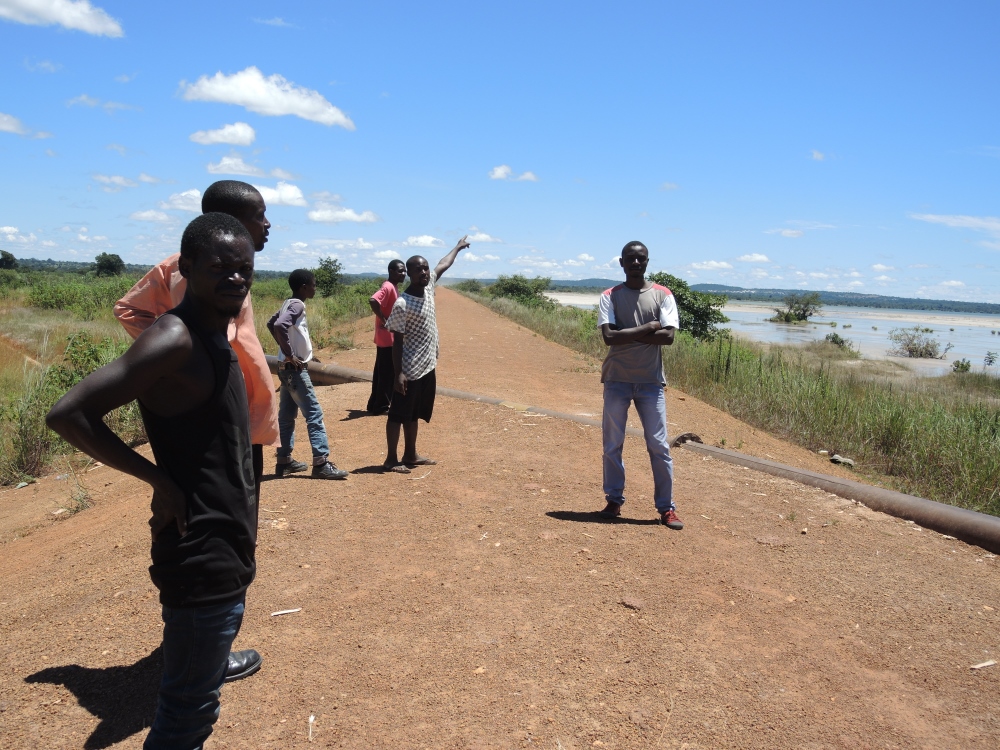 A group of young men on their way to fish in the Kafue River pass next to the Lubengele Tailings Dam. Konkola Copper Mines, which operates the dam, was found guilty of polluting the Kafue River in 2006 near the town of Chingola with acidic waste from the mines. All of the men in the picture had family working in the mines. (Melanie Lidman)