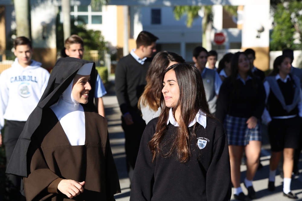 Sr. Ines walks with a student at ACC high school. The Carmelite Sisters administer an Archbishop Coleman F. Carroll, an archdiocesan high school in the Kendall area of Miami and also teach at the J. Serra Catholic High School in San Juan Capistrano, Calif. (Courtesy of Carmelite Sisters of the Most Sacred Heart of Los Angeles)