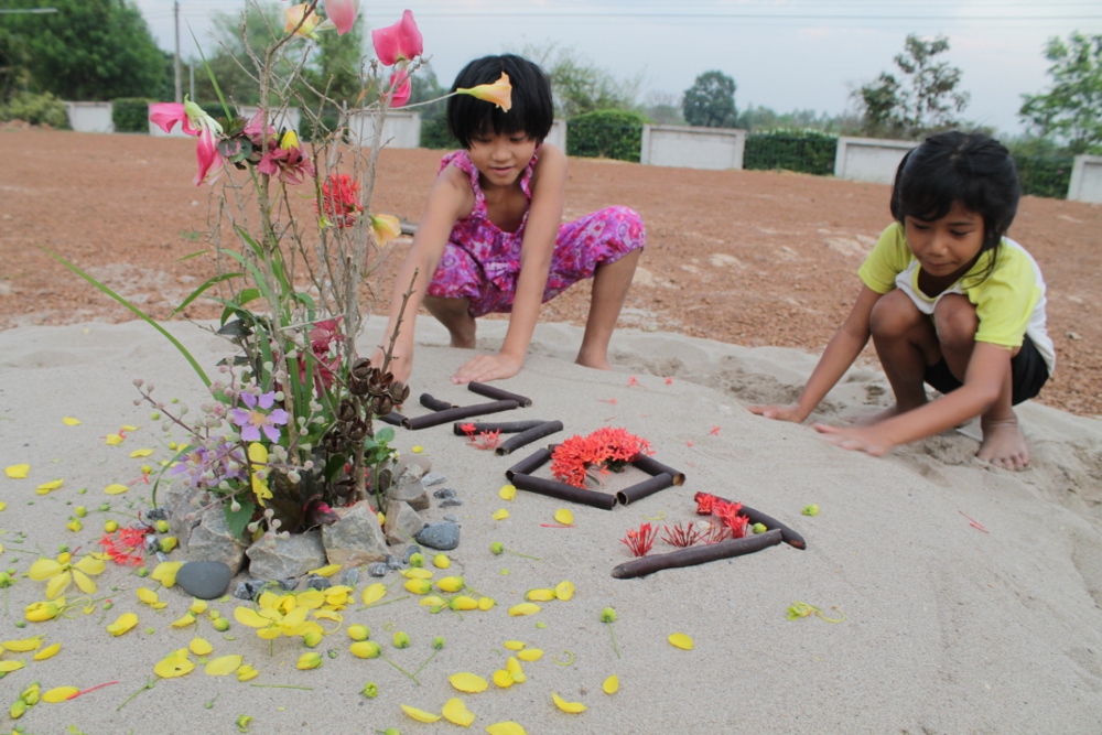 Nonnie and Panda are building a "love" sand sculpture. Nonnie, 7, is HIV-negative, born to parents who are HIV-positive, and Panda, 9, is an HIV-positive and being raised by her grandparents. (Bridgid O’Brien)