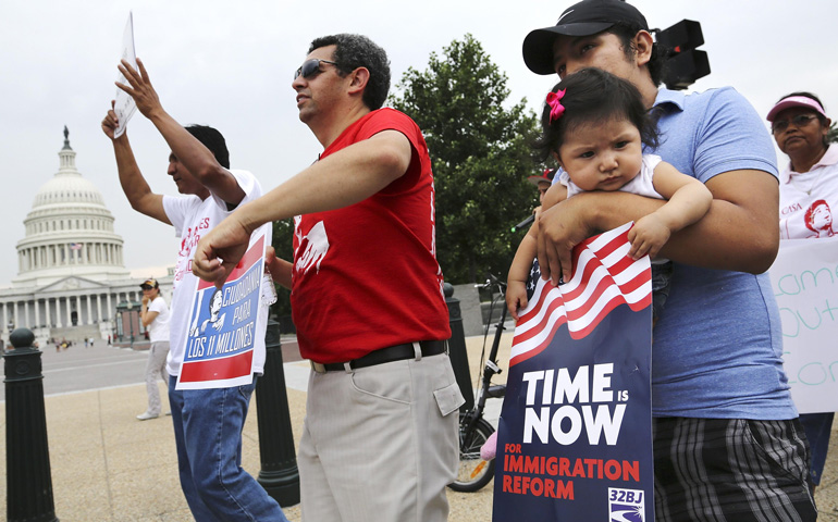 A group of immigrants and activists for immigration reform chant Wednesday as they march on Capitol Hill in Washington to urge Congress to act on immigration reform. (CNS/Reuters/Jonathan Ernst)