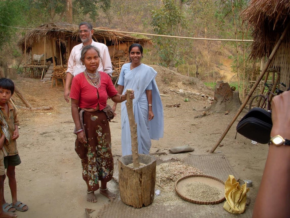 Sr. Janet Tellis visits with a woman from the Tripuri tribe who pauses from her work removing husk from rice harvested from a paddy. (Photo provided by Janet Tellis)