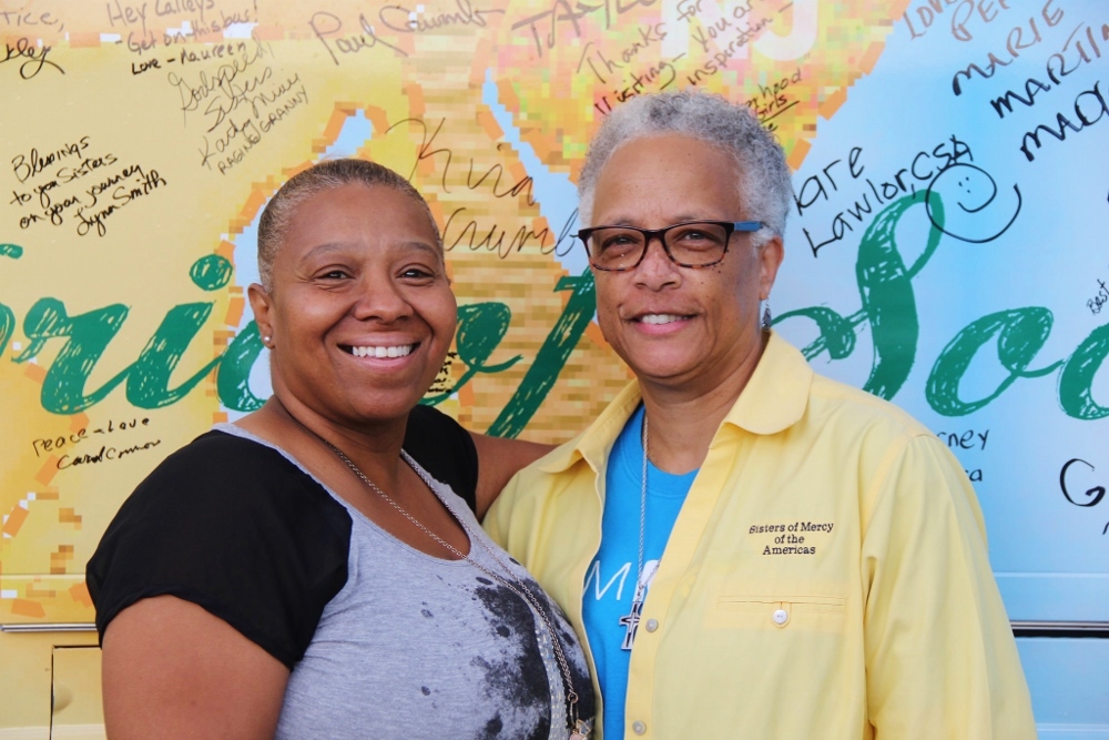 Sr. Larretta Rivera-Williams, right, with Ms. Angie, client of Central Missouri Community Action's Cole County Family Resource Center in Jefferson City, Mo. They are standing by the 2016 Nuns on the Bus bus, which already has plenty of signatures even on Day 3 of the tour. (Jennifer Wong / Courtesy of NETWORK)