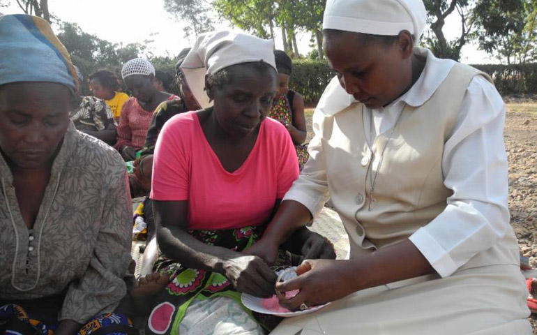 Sr. Josephine Muthoni Kwenga, a Sister of St. Joseph of Tarbes, right, helps a woman make a bracelet during one of the training sessions. (Melanie Lidman)