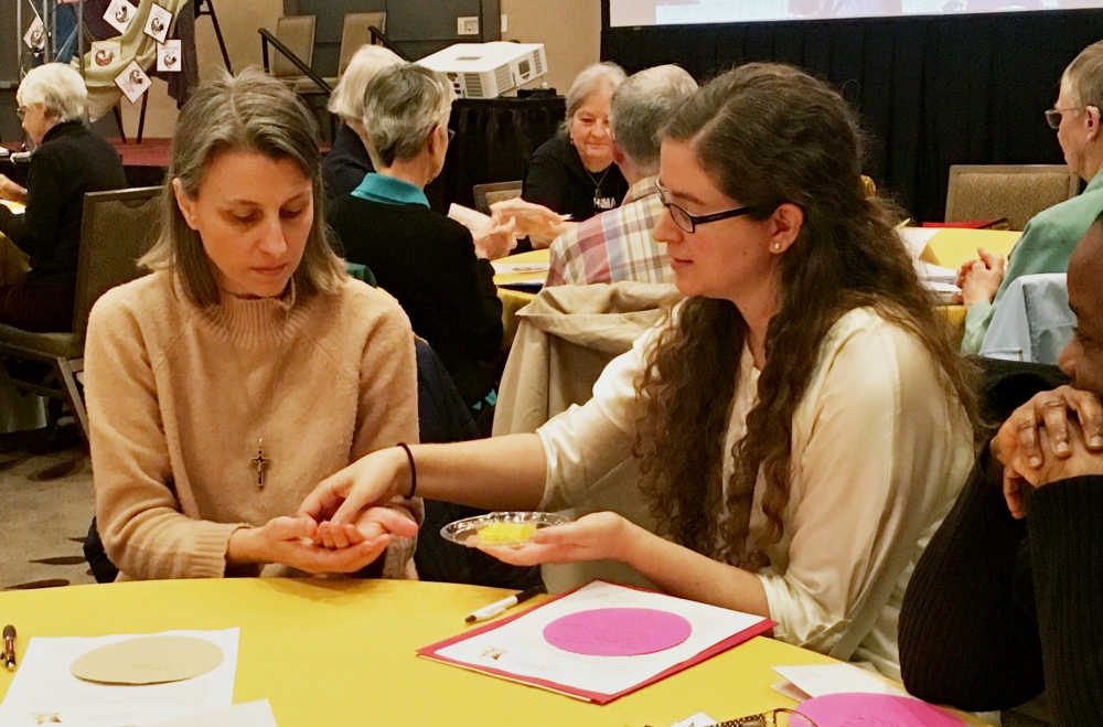 Jennifer Reyes Lay, assistant director of the Office of Justice, Peace and Integrity of Creation for the Sisters of Charity of the Incarnate Word, anoints Sr. Kari Pohl, justice and peace coordinator for the Sisters of St. Joseph of Baden, Pennsylvania. Reyes Lay led a breakout workshop on "Wrestling with the Legacy of White Supremacist Colonial Christianity." (Pamela Schaeffer)