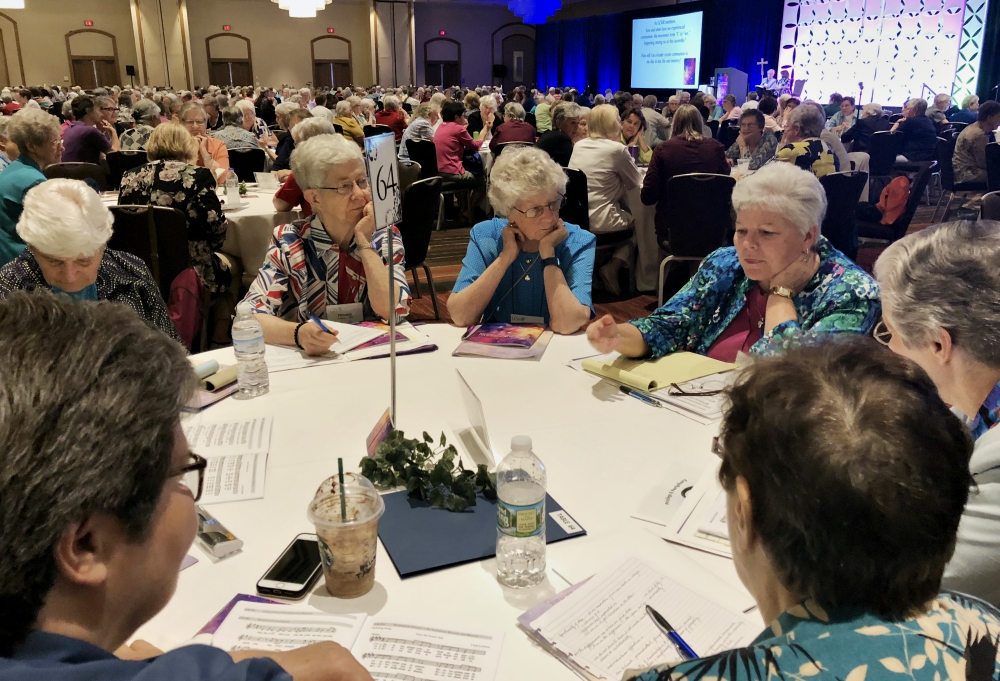 Sisters share their thoughts with the other sisters at their tables after a keynote speaker at the 2018 Leadership Conference of Women Religious annual assembly, held Aug. 7-10 in St. Louis. (GSR file photo)