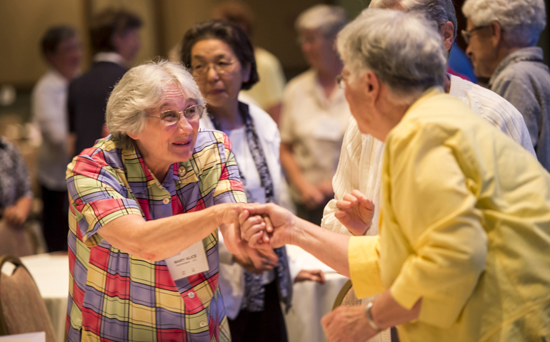 Attendees exchange the sign of peace during Mass at the 2013 assembly of the Leadership Conference of Women Religious. (CNS/Roberto Gonzalez)