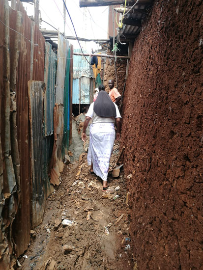 Sr. Mary Magdalene Kanini walks through an alley in a Kibera slum to visit William Nyambongi. His legs were broken when he was beaten by police during protests in Nairobi following the announcement of the contested presidential election results in August. (Lilian Muendo)