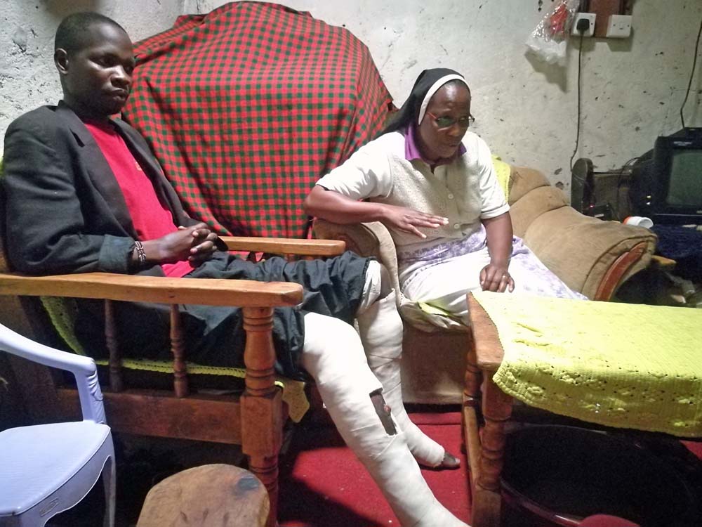 Sr. Mary Magdalene Kanini visits William Nyambongi at his house to monitor his progress. Nyambongi was beaten by police and left for dead with his legs broken. He is not able to walk. (Lilian Muendo)