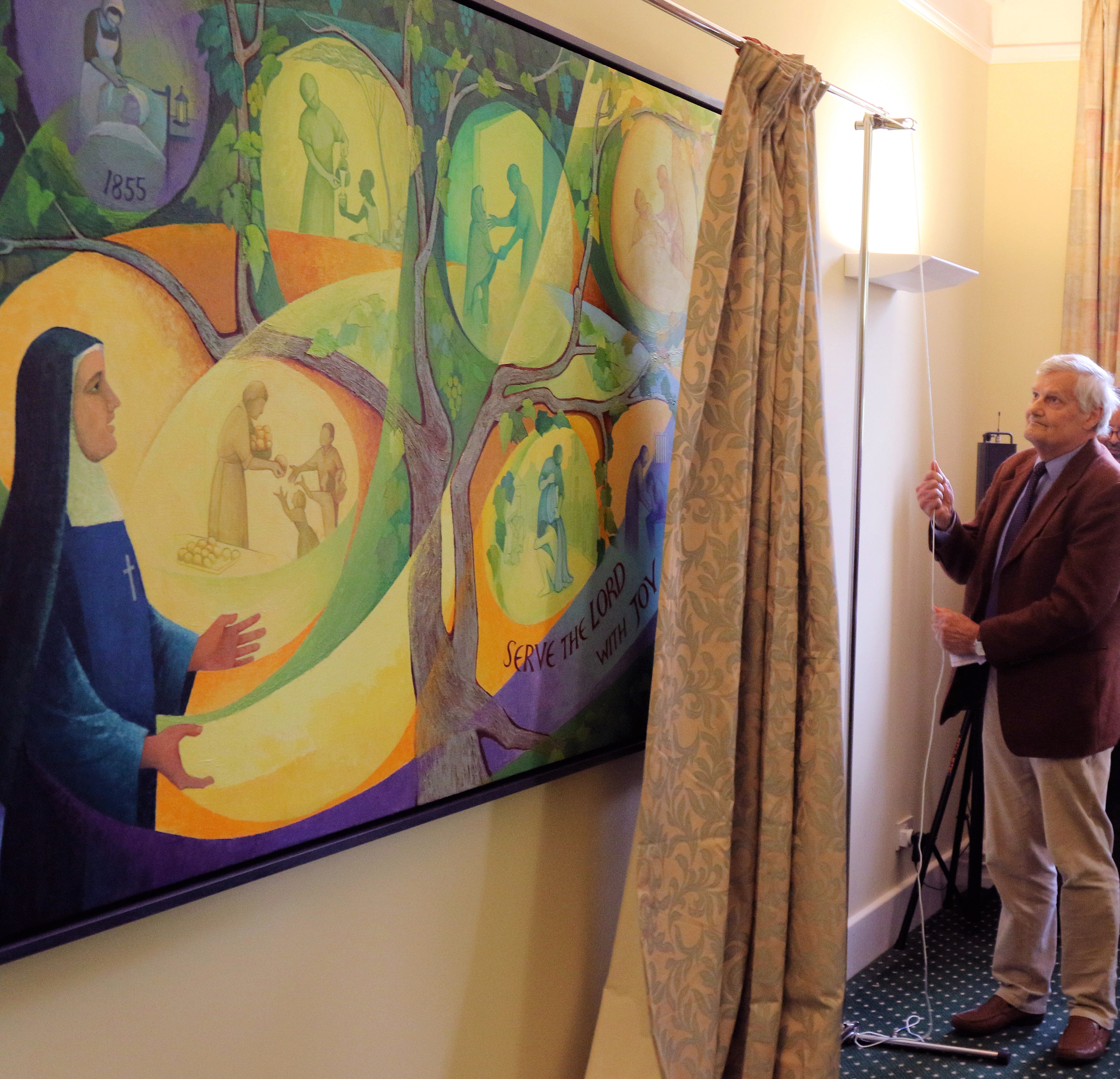 A man unveils Mother Joanna Jamieson's mural of Venerable Magdalen Taylor on Sept. 26 at the Kairos Centre in London. (CNS / Simon Caldwell)