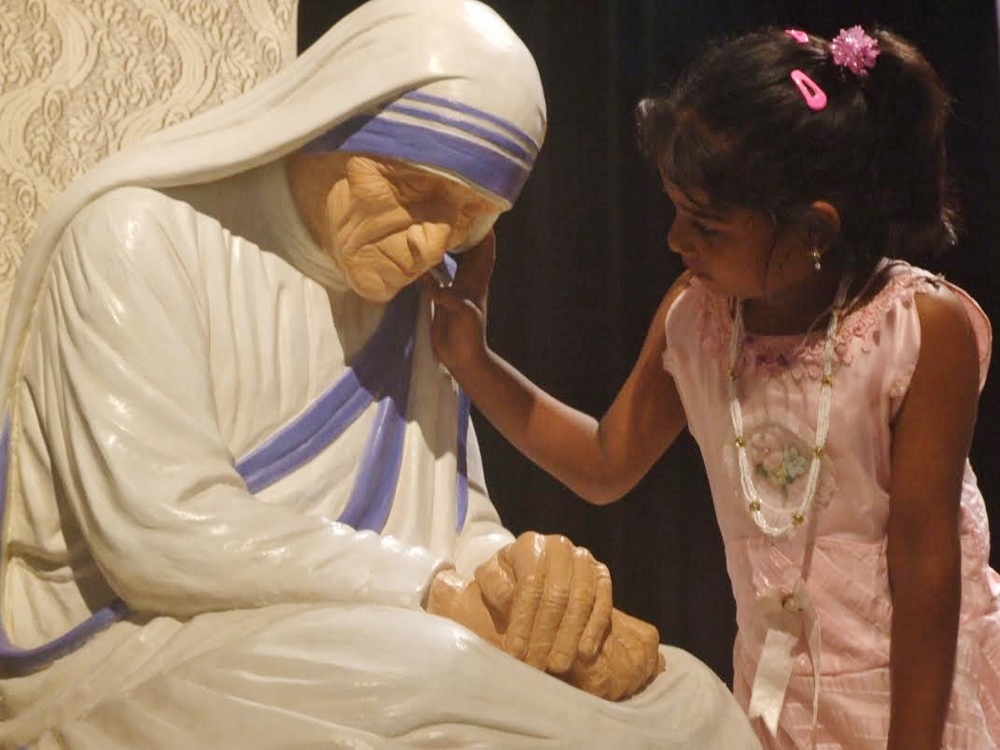 A human touch: a girl caressing the statue of Mother Teresa during an exhibition on Mother's birth centenary in Kolkata. (GSR photo / Julian S. Das)