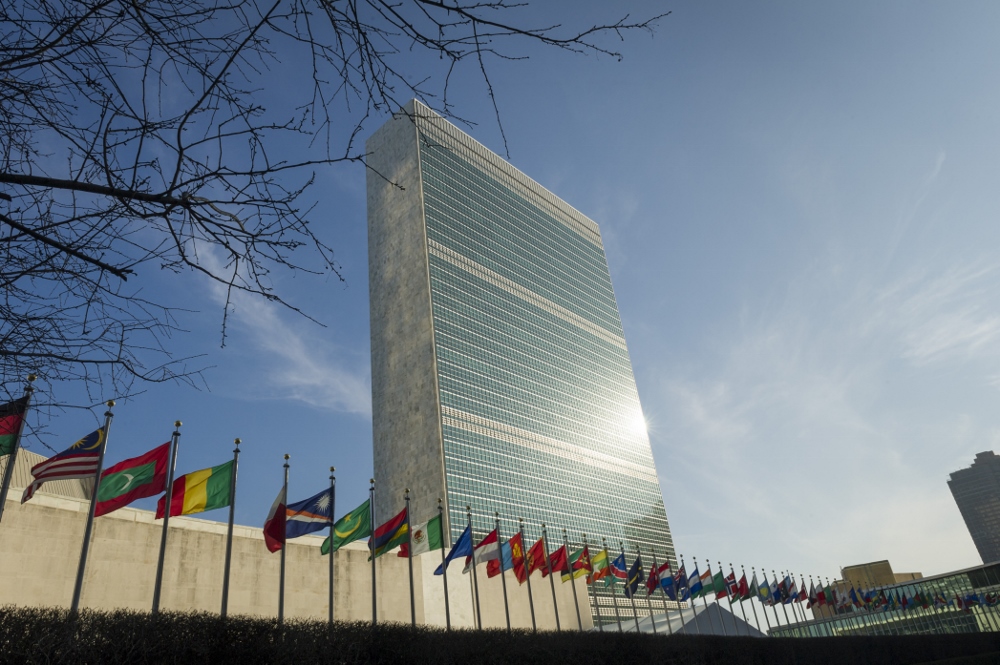A view of the Secretariat Building, with U.N. members states' flags flying in the foreground, at United Nations headquarters in New York. (U.N. photo / Rick Bajornas)